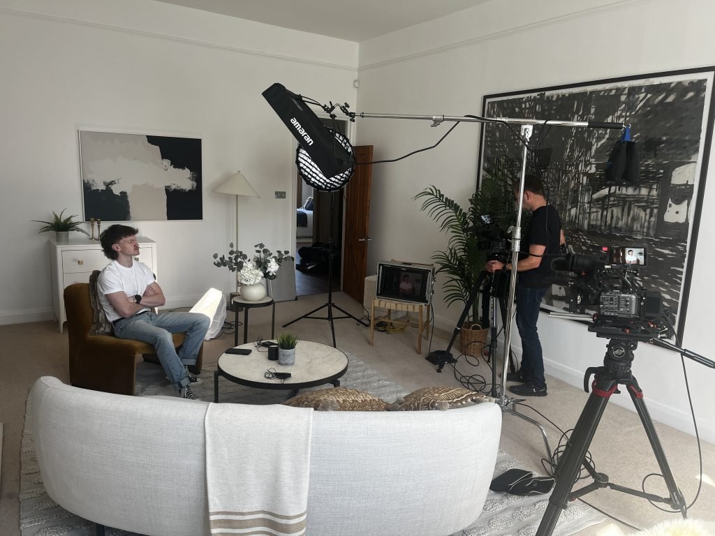 Camera and lighting set up to film an interview in a home setting